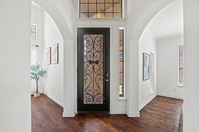 4504 Oxbow Dr, Mckinney, TX 75072 - foyer featuring dark wood-style flooring, baseboards, arched walkways, and crown molding