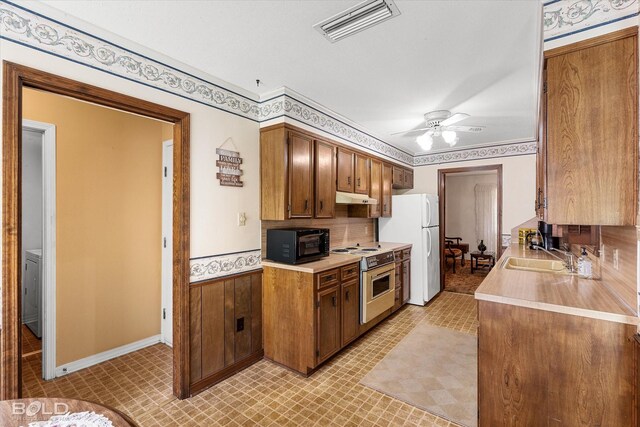 6307 Bocage Dr, Shreveport, LA 71119 - kitchen featuring black microwave, freestanding refrigerator, under cabinet range hood, visible vents, and range with electric cooktop