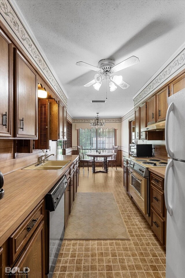6307 Bocage Dr, Shreveport, LA 71119 - kitchen with range with electric stovetop, freestanding refrigerator, under cabinet range hood, dishwashing machine, and ceiling fan with notable chandelier
