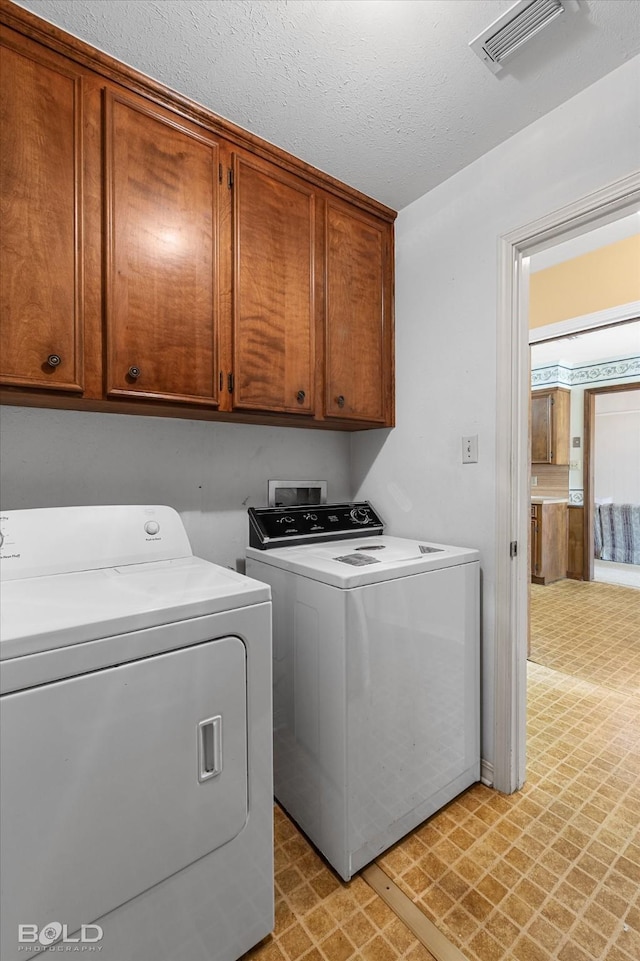 6307 Bocage Dr, Shreveport, LA 71119 - washroom featuring washing machine and clothes dryer, cabinet space, visible vents, and light floors