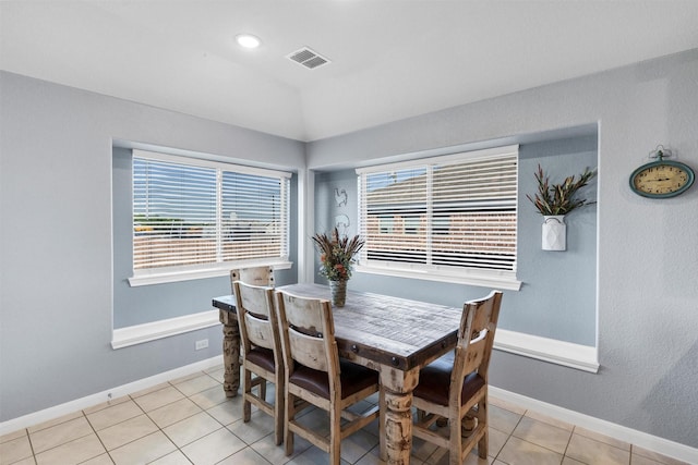 dining area featuring visible vents, baseboards, light tile patterned flooring, and vaulted ceiling