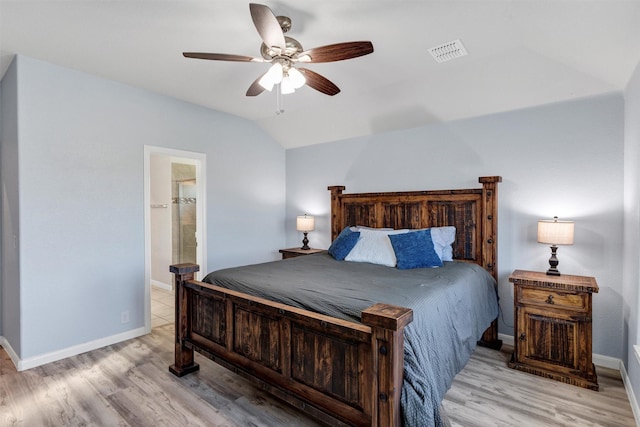 bedroom featuring visible vents, light wood-type flooring, baseboards, and lofted ceiling