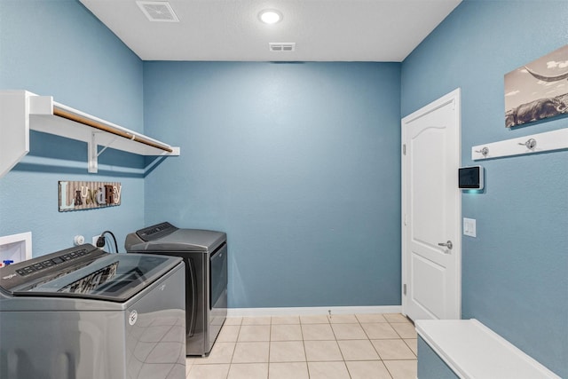 laundry area with visible vents, independent washer and dryer, laundry area, and light tile patterned floors