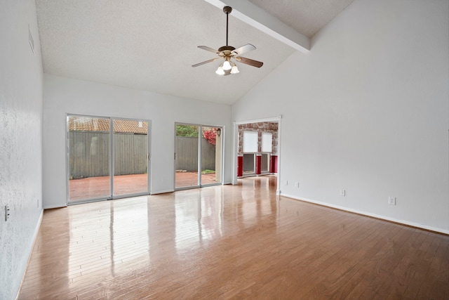 spare room featuring beamed ceiling, a ceiling fan, wood finished floors, high vaulted ceiling, and baseboards