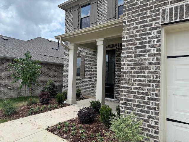 doorway to property with brick siding and a garage