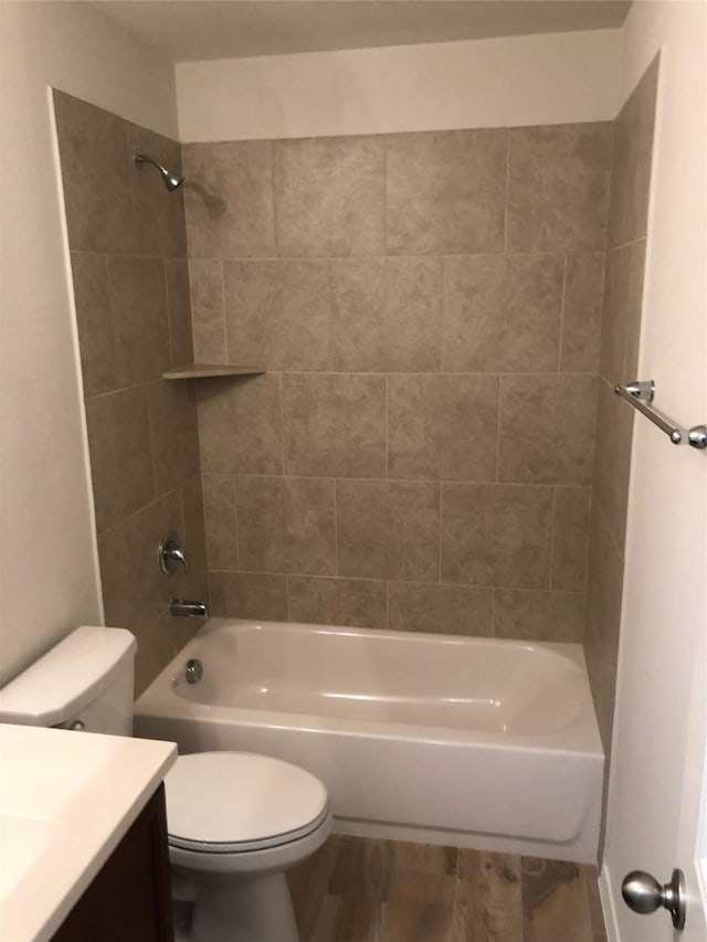 full bath featuring wood finished floors, toilet, vanity, and bathing tub / shower combination
