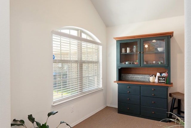 carpeted office space featuring vaulted ceiling