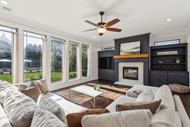 2413 Versailles Dr, Heath, TX 75032 - living area featuring dark wood-type flooring, crown molding, ceiling fan, a stone fireplace, and recessed lighting