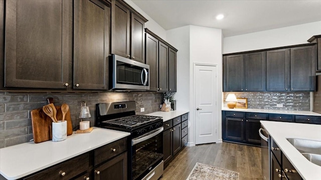 kitchen featuring light countertops, appliances with stainless steel finishes, dark brown cabinetry, and decorative backsplash
