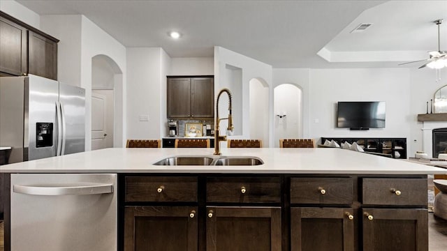 kitchen with visible vents, dark brown cabinetry, stainless steel appliances, and a sink