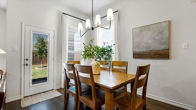 dining room featuring plenty of natural light, baseboards, a chandelier, and dark wood-type flooring