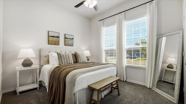 bedroom featuring baseboards, a ceiling fan, carpet flooring, and multiple windows