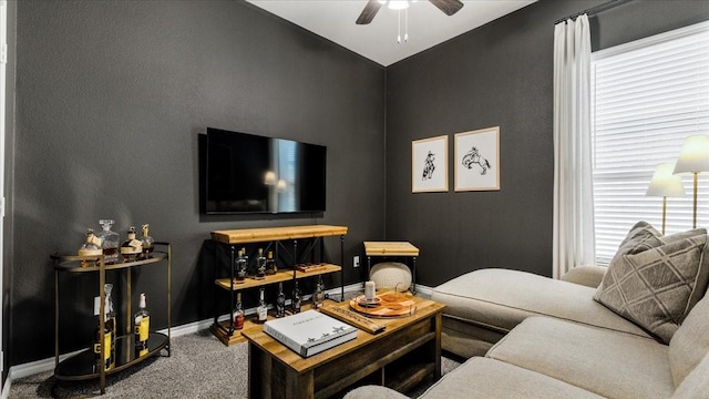 carpeted living room with baseboards and a ceiling fan