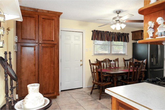 dining space featuring a ceiling fan and light tile patterned flooring