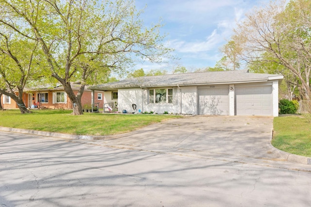 ranch-style house with a garage, concrete driveway, and a front lawn