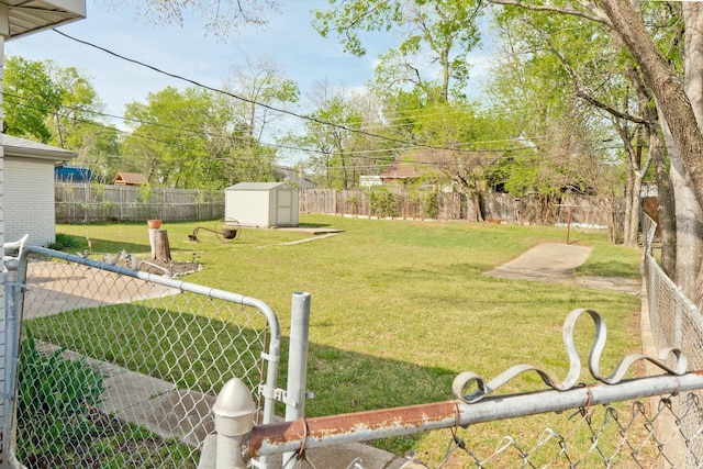 view of yard with an outbuilding, a fenced backyard, and a storage unit