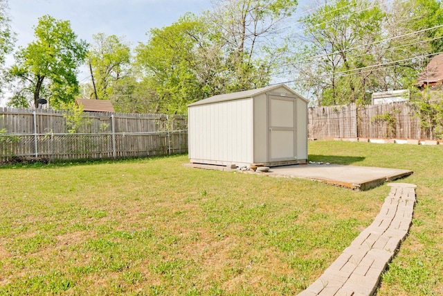 view of yard with a storage unit, a fenced backyard, and an outdoor structure