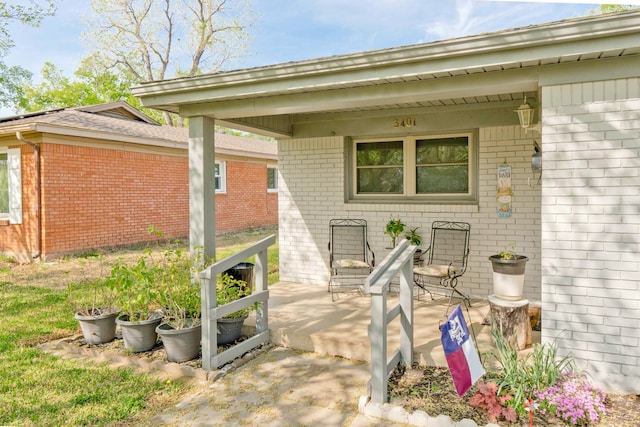 property entrance featuring brick siding and covered porch