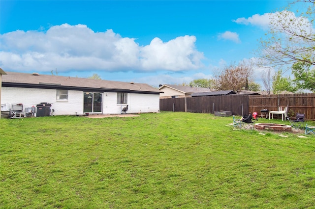 back of house featuring a patio area, a fire pit, a fenced backyard, and a lawn