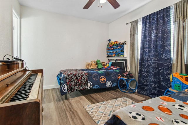 bedroom with ceiling fan, baseboards, and wood finished floors
