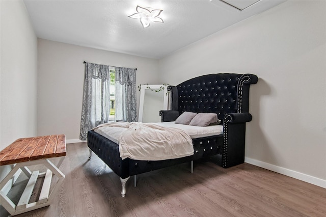 bedroom featuring wood finished floors and baseboards