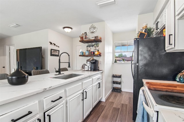 kitchen with dark wood-style flooring, open shelves, white cabinets, light stone countertops, and a sink