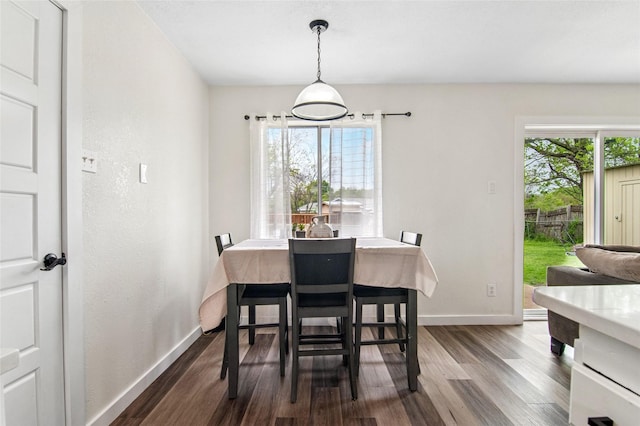 dining space with baseboards and dark wood-style floors