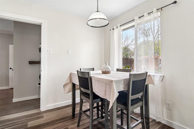 dining space featuring baseboards and wood finished floors
