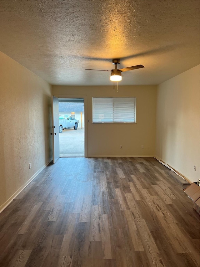 empty room featuring a textured ceiling, wood finished floors, and a wealth of natural light