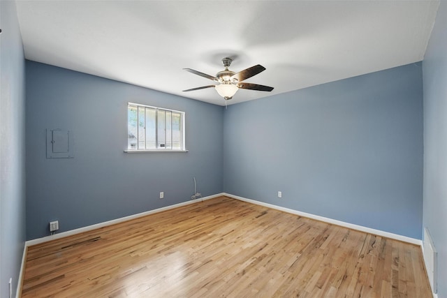 spare room with baseboards, visible vents, wood finished floors, and ceiling fan