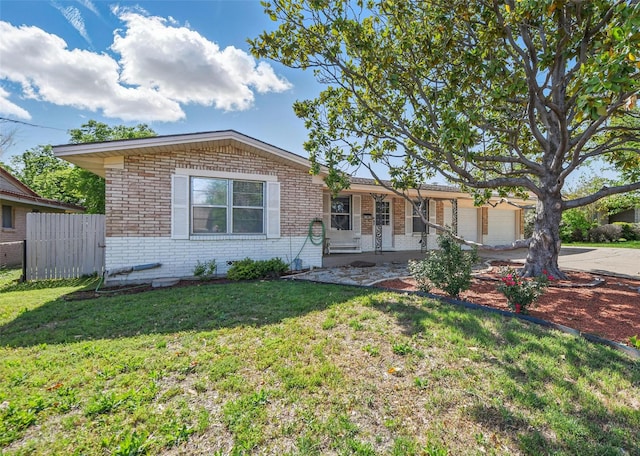 ranch-style house with concrete driveway, an attached garage, fence, brick siding, and a front lawn