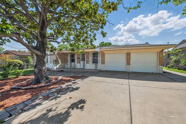 ranch-style home with concrete driveway, an attached garage, and brick siding