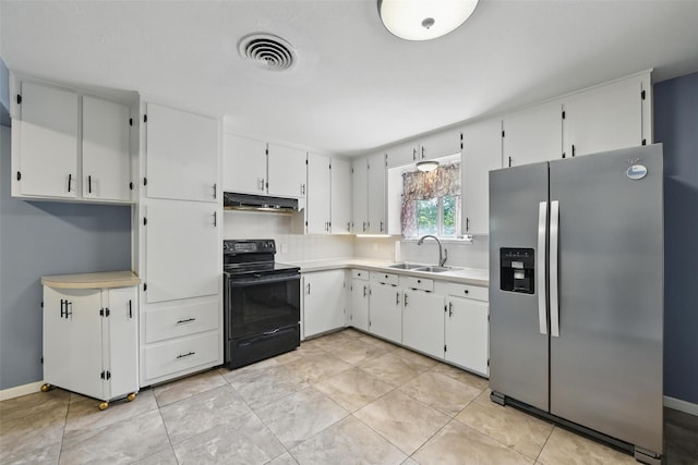 kitchen featuring stainless steel fridge, under cabinet range hood, black / electric stove, a sink, and visible vents