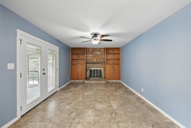 unfurnished living room featuring a brick fireplace, a ceiling fan, built in features, and baseboards