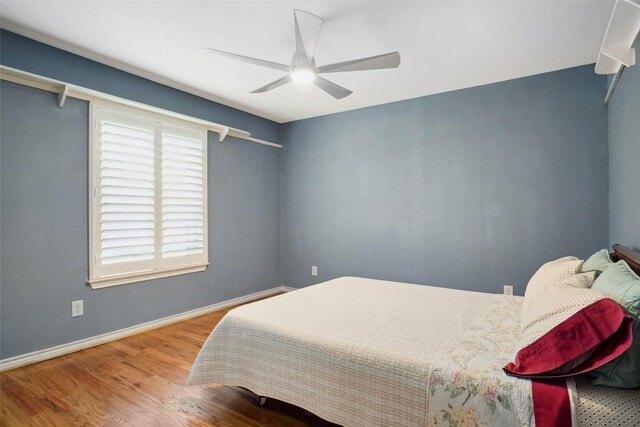 2833 S Country Club Rd, Garland, TX 75043 - bedroom featuring baseboards, ceiling fan, and wood finished floors