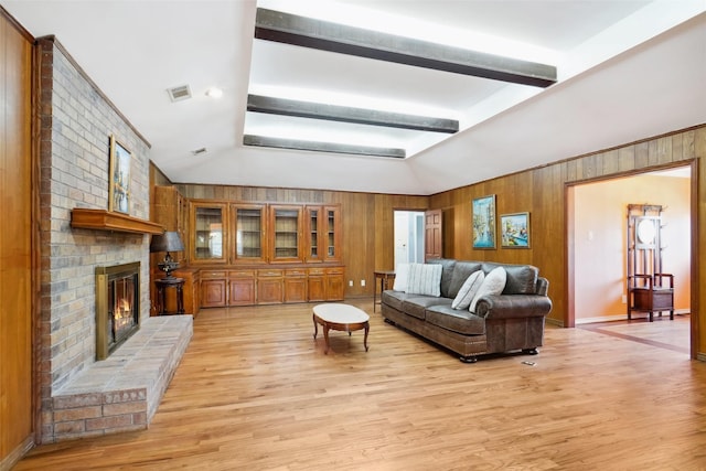 2833 S Country Club Rd, Garland, TX 75043 - living area featuring visible vents, a brick fireplace, light wood finished floors, vaulted ceiling, and wood walls