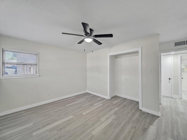 unfurnished bedroom with wood finished floors, ceiling fan, baseboards, and visible vents