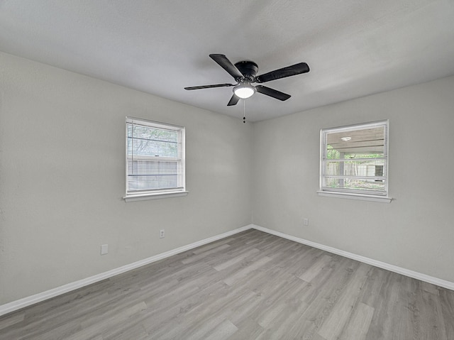 unfurnished room with baseboards, a ceiling fan, and wood finished floors