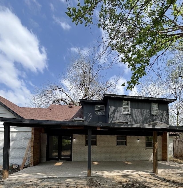 view of front of house featuring brick siding, a patio, and an attached carport