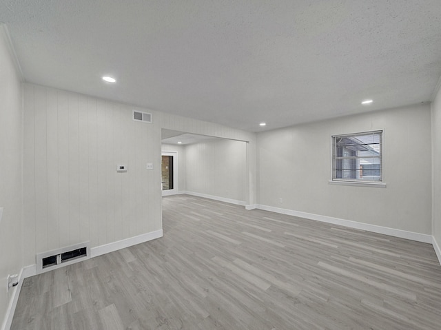 interior space with wood finished floors, baseboards, and visible vents
