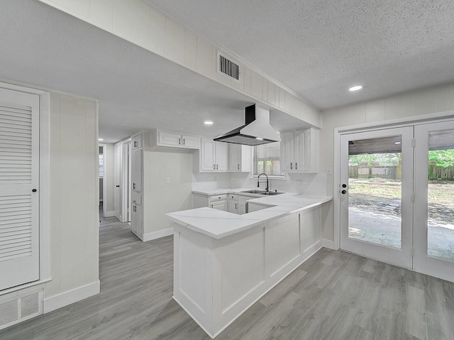 kitchen with a peninsula, baseboards, and visible vents