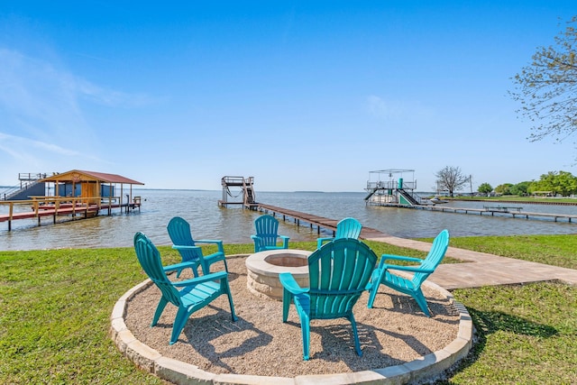 dock area with a fire pit, a yard, a water view, and boat lift