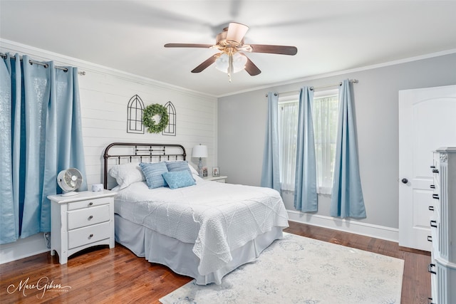 bedroom with wood finished floors, ceiling fan, baseboards, and ornamental molding