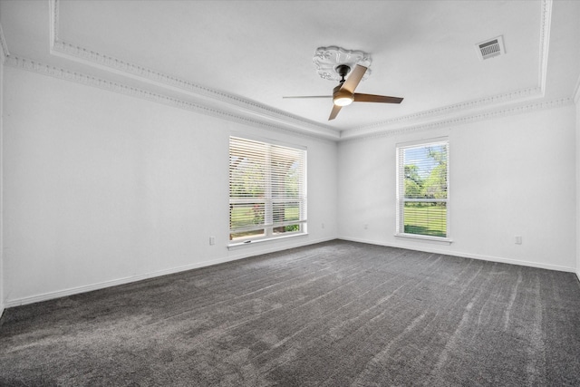 empty room featuring visible vents, baseboards, ceiling fan, crown molding, and a tray ceiling