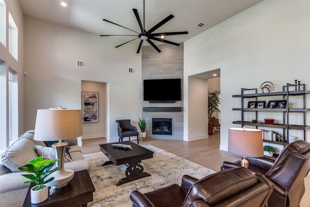 2313 Sandlin Dr, Fort Worth, TX 76008 - living area with visible vents, a ceiling fan, a towering ceiling, and a fireplace