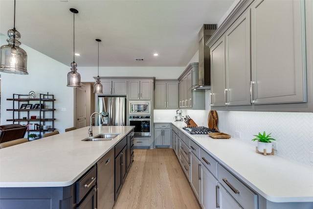 2313 Sandlin Dr, Fort Worth, TX 76008 - kitchen with light wood-type flooring, gray cabinets, wall chimney exhaust hood, appliances with stainless steel finishes, and a sink