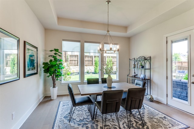 2313 Sandlin Dr, Fort Worth, TX 76008 - dining space featuring a chandelier, wood finished floors, a tray ceiling, and baseboards