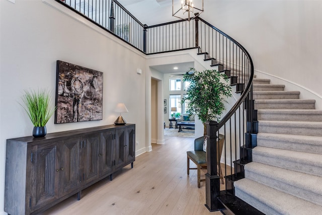 2313 Sandlin Dr, Fort Worth, TX 76008 - stairway with wood finished floors, a towering ceiling, baseboards, and a notable chandelier