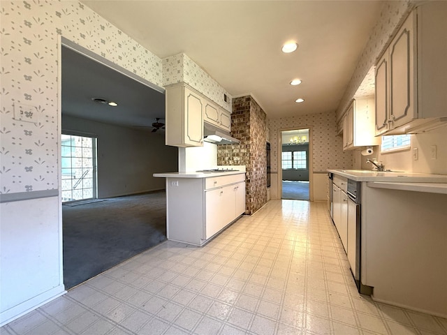 10016 Clearmeadow Dr, Dallas, TX 75238 - kitchen with wallpapered walls, light countertops, under cabinet range hood, cooktop, and a sink