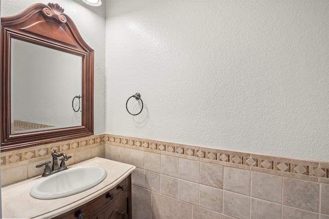 bathroom with vanity, tile walls, and wainscoting